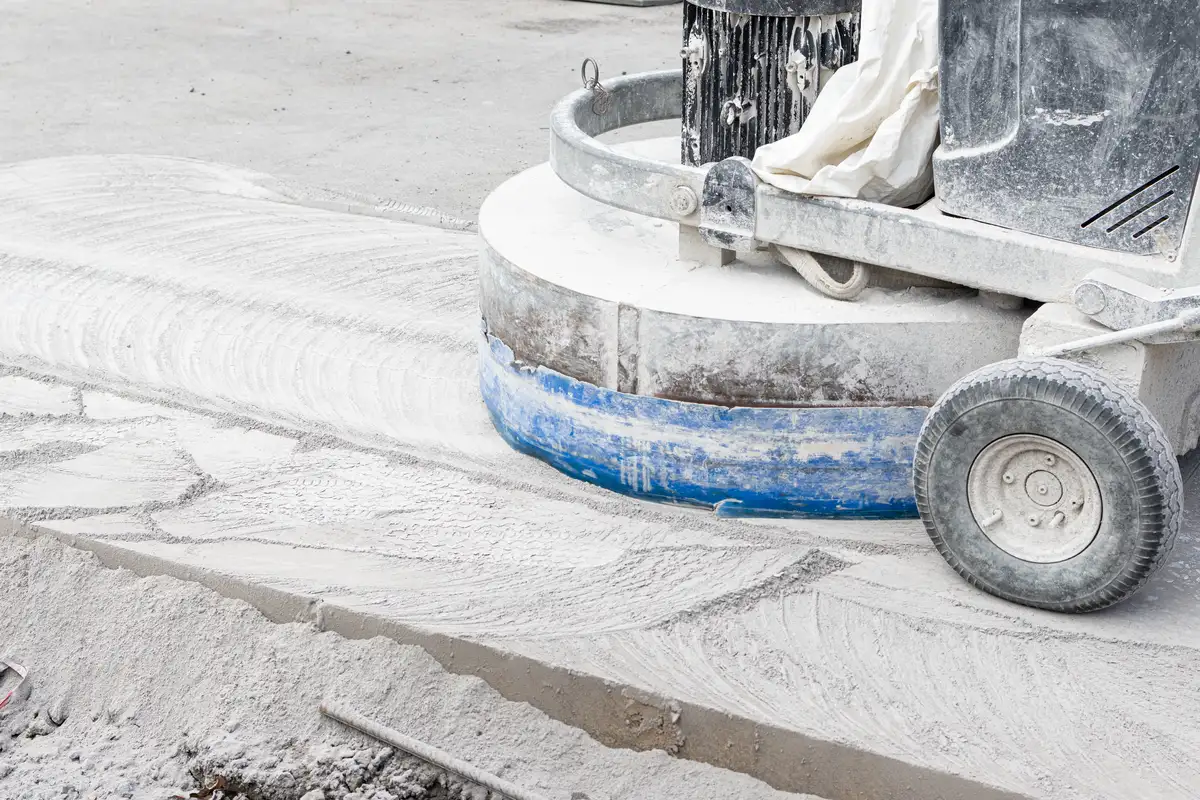 Bodenfräse glättet staubige Betonfläche im Rahmen der Betoninstandsetzung