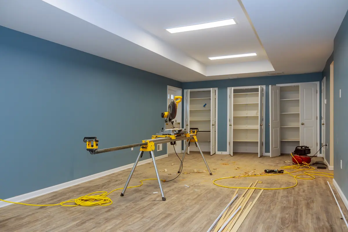 Zimmer mit Sägetisch, Holzbodenleisten und Regalböden bei Kellersanierung